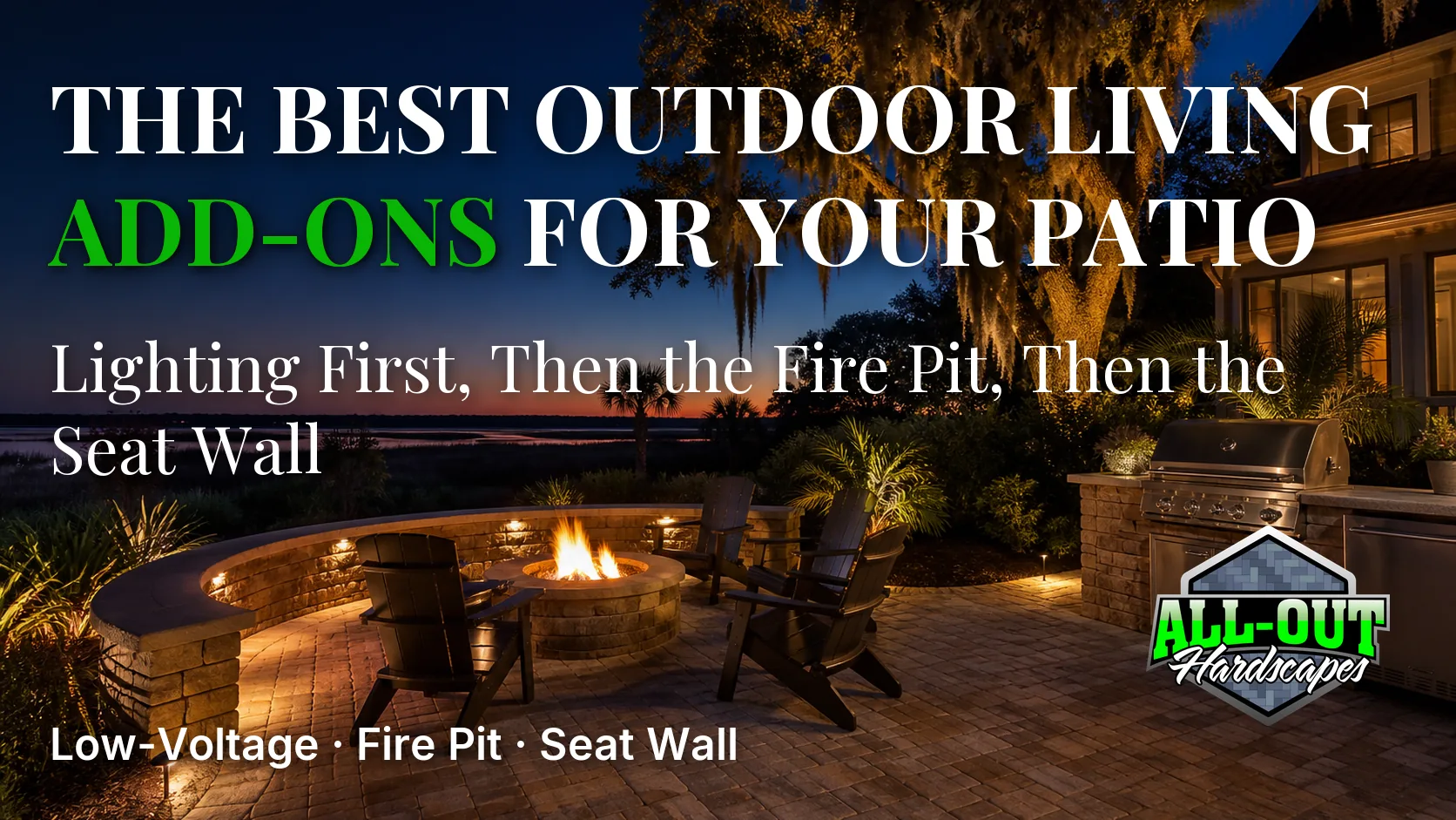 A lit Savannah paver patio at blue hour with a fire pit and a curved seat wall